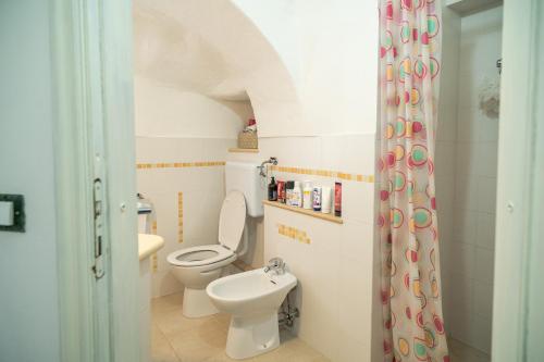 une salle de bain avec toilettes et lavabo dans l'établissement Trullo Tre Coni, à Cisternino