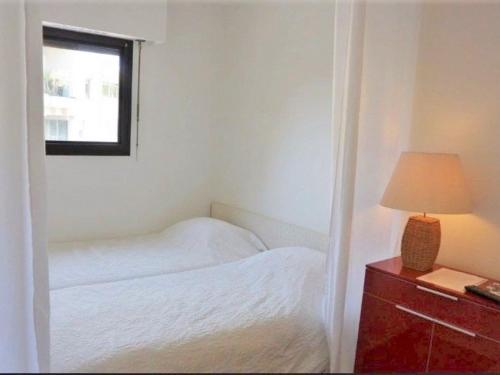 une chambre avec un lit, une lampe et une fenêtre dans l'établissement Studio climatisé avec piscine et Wi-Fi, à 150m des plages et du centre-ville de Cannes - FR-1-609-41, à Cannes