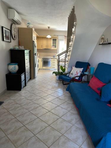 a living room with a blue couch and a kitchen at Cozy Blu in Nikiti