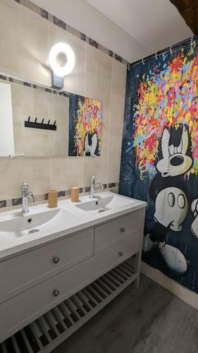 une salle de bain avec deux lavabos et un grand miroir dans l'établissement Esbly Merveilleux Disney Home 6 à 8 pers, à Esbly