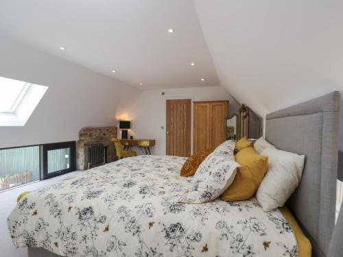 a bedroom with a large bed with pillows on it at The Hay Barn in Gloucester