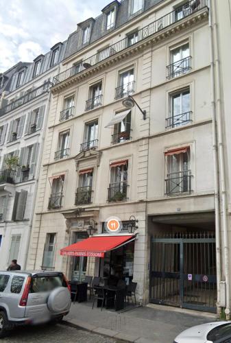 un grand bâtiment avec un auvent rouge devant lui dans l'établissement Elegant Triplex - Tour Eiffel Invalides, à Paris