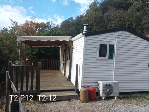 a small white shed with a porch and a roof at Domaine Plein Sud in Bruzac
