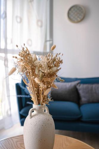 un vase blanc assis sur une table avec des fleurs. dans l'établissement Le VAL HOME - 20min de PARIS et ORLY - Balcon - WIFI - Espace de travail, à Valenton