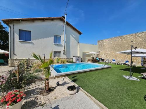une cour arrière avec une piscine et une maison dans l'établissement Partie de villa, à Velleron