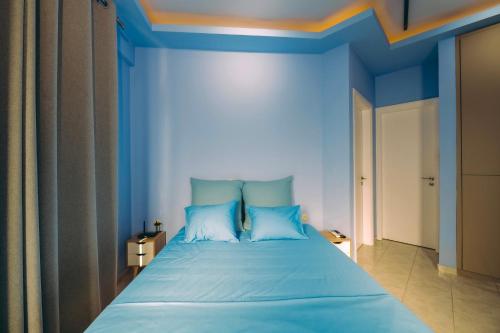 a blue bedroom with a large bed with blue walls at Ananda Apartments in Skafidia