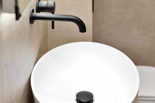 ein weißes WC im Bad mit schwarzem Griff in der Unterkunft Oceanfront villa Casa Mar Azul in Kralendijk