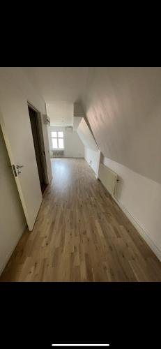 an empty room with a wooden floor and a window at Nya 1or 2or i centrala Halmstad in Halmstad