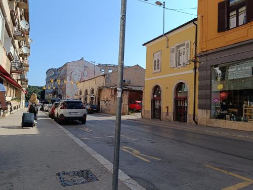 a street with cars parked on the side of the road at D&A Amphitheatre Premium Apartments with FREE Parking in Pula