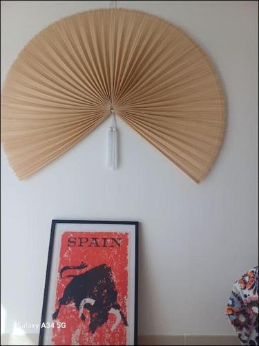 a large wooden umbrella on a wall next to a picture at Studio mi casa es su casa in Vauvert