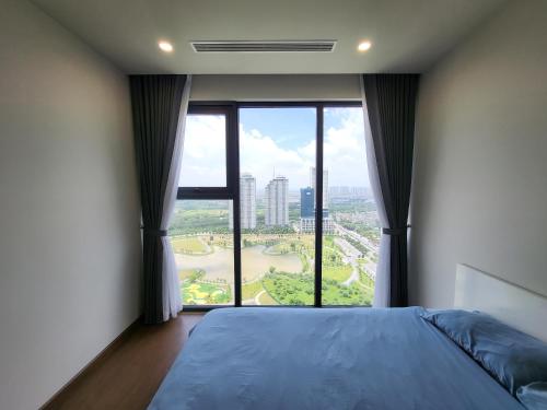 a bedroom with a bed and a large window at Căn hộ dịch vụ The Matrix One siêu đẹp in Hanoi