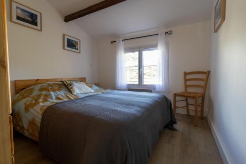 une chambre avec un lit, une chaise et une fenêtre dans l'établissement Au pied de la Sainte Baume, à Plan dʼAups