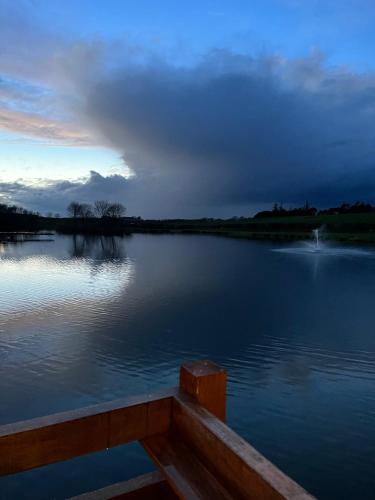 a view of a lake with a boat in the water at Stewards Bothy in Cornhill-on-tweed