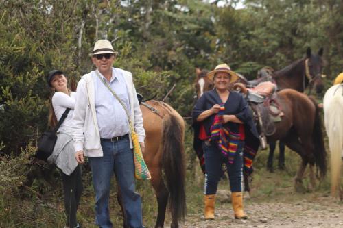 two men and a woman standing next to a horse at Escala 100 Organic Farm Glamping cerca a Bogotá in Fosca