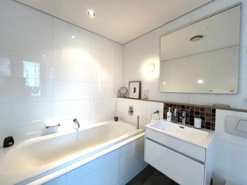 Un baño blanco con bañera y lavabo. en #608 Cartwright - Urban Hideaway, en Ciudad del Cabo