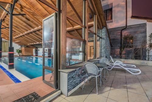 a house with a pool and a patio with chairs at Kopala Tskneti Hotel in Tsqnetʼi