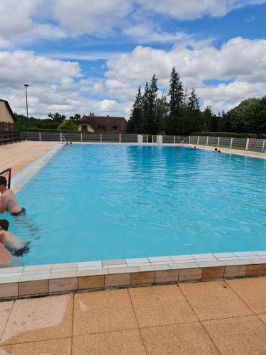 une grande piscine avec de l'eau bleue dans l'établissement Maison normande, à Freneuse-sur-Risle