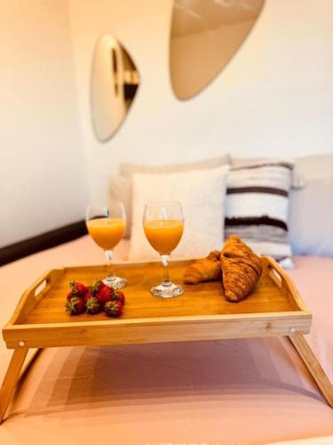 - une table avec deux verres de jus d'orange et des croissants dans l'établissement Le Cosy Du Roi, WIFI,GARE,PARIS, à Versailles