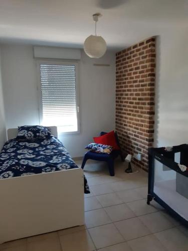 une chambre avec un lit et un mur de briques dans l'établissement Spacieux logement Prado Rabateau idéal Famille, à Marseille