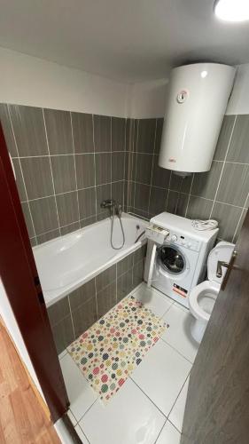 a bathroom with a bath tub and a washing machine at Chalupa pri Váhu in Nezbudská Lúčka