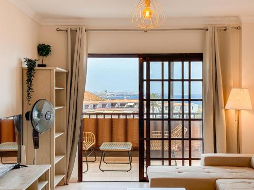 a living room with a view of a balcony at Seaside apartment with a sea view in Costa Del Silencio
