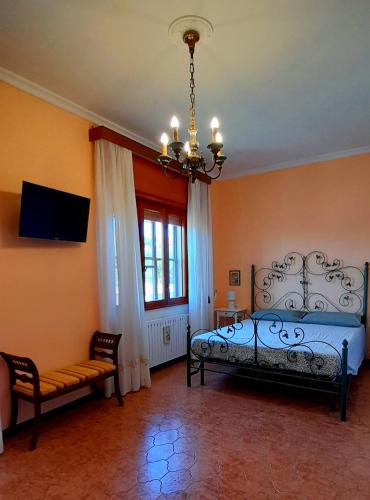 a bedroom with a bed and a chandelier at Il Corniolo in Tarquinia