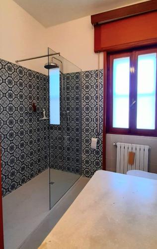 a glass shower in a room with a table at Il Corniolo in Tarquinia