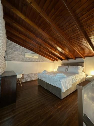 a bedroom with a bed and a wooden ceiling at Stenakas Apartments in Chios