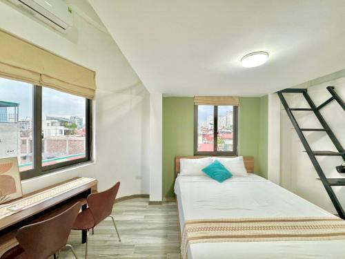 a bedroom with a bed and a desk and windows at The Little Hanoi -Modern-Balcony in Hanoi
