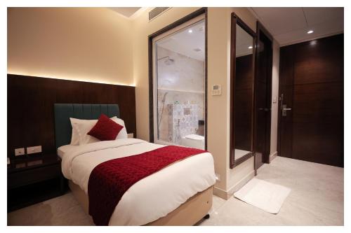a bedroom with a large bed and a bathroom at HOTEL ROYAL VILAS9 in Gajraula