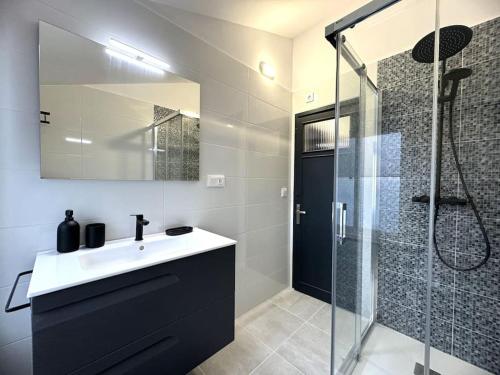 a bathroom with a sink and a glass shower at Ático Playa Foz con Terraza in Foz