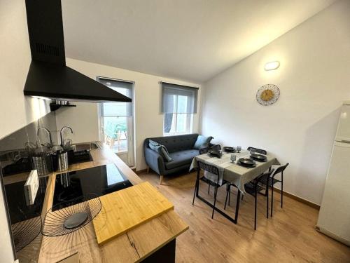 a kitchen and living room with a table and a couch at Ático Playa Foz con Terraza in Foz
