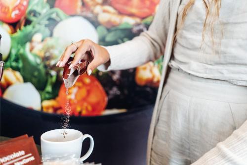 a woman is pouring coffee into a cup at Stay Hotel Lisboa Aeroporto in Lisbon
