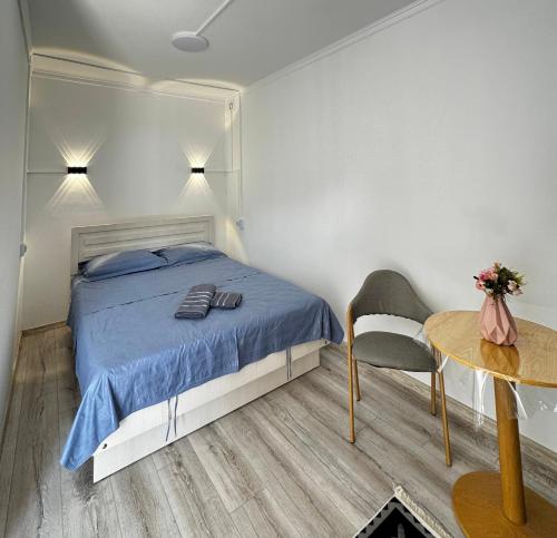 a bedroom with a bed and a table with a chair at Nomads Home in Bishkek