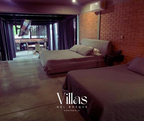 a hotel room with two beds and a dining area at Villas del Bosque in El Pueblito