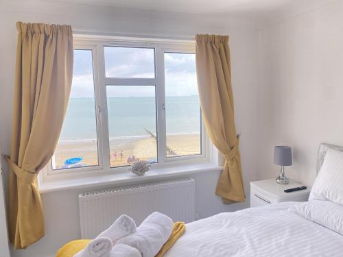 1 dormitorio con ventana y vistas a la playa en Gurnard At The Aqua, en Shanklin