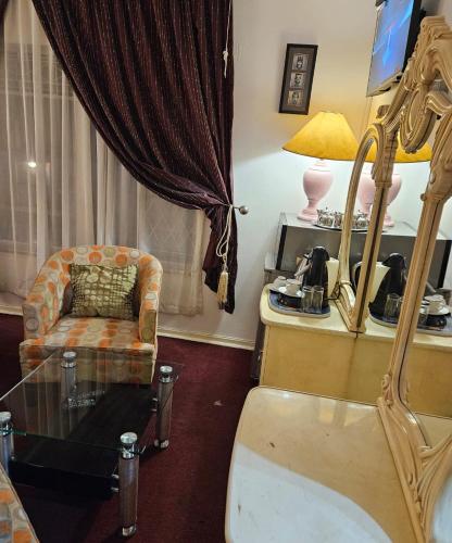 a living room with a chair and a glass table at The Royal Princess B&B on Malibongwe Drive in Johannesburg