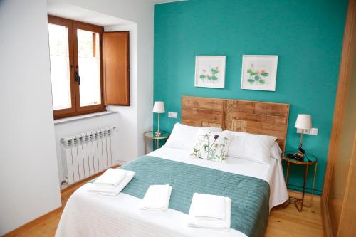 a bedroom with two beds and a blue wall at Casa Muiño dos Frades in Lourenzá