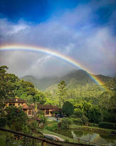 a rainbow in the sky over a mountain at Parador Lumiar Boutique Hotel & Spa in Lumiar