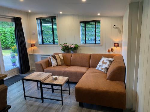 a living room with a couch and a table at 'T Veluwse Boshuus chalet 44 in Hattemerbroek