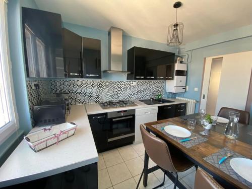 une cuisine avec un comptoir et une table avec des chaises dans l'établissement Appartement 6 couchages près CHU - Daguerre, à Clermont-Ferrand