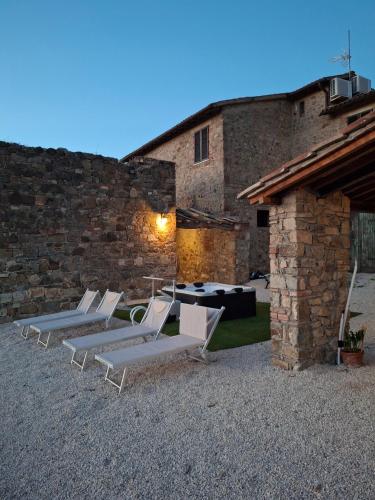 a group of lounge chairs in front of a building at Agriturismo Capannacce in Bagno Vignoni