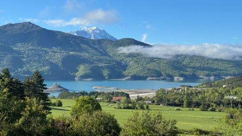 Elle offre une vue sur une chaîne de montagnes et un lac. dans l'établissement Domaine de la baie Saint-Michel le Piolit, à Prunières