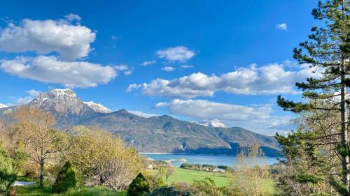 une vue d'un lac avec des montagnes en arrière-plan dans l'établissement Domaine de la baie Saint-Michel le Piolit, à Prunières