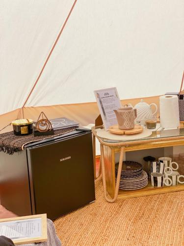 a microwave sitting next to a table and a tent at Glempings MIGLA in Dalbe