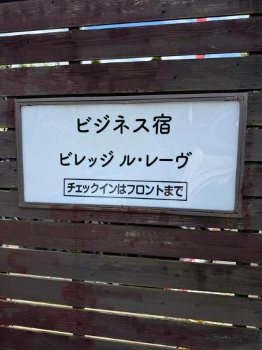 a sign on a wall with asian writing on it at Village lereve in Takeo