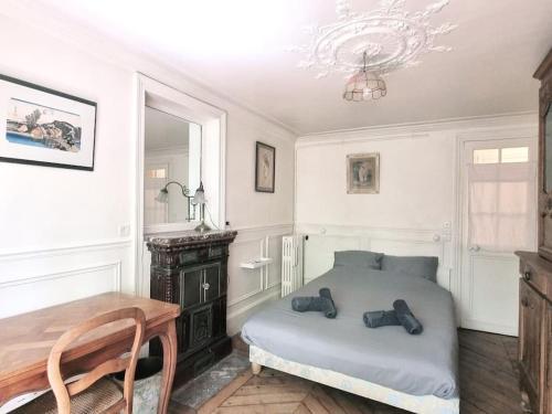une chambre avec un lit, une table et un lustre dans l'établissement Paris Montmartre 6 Personnes, à Paris