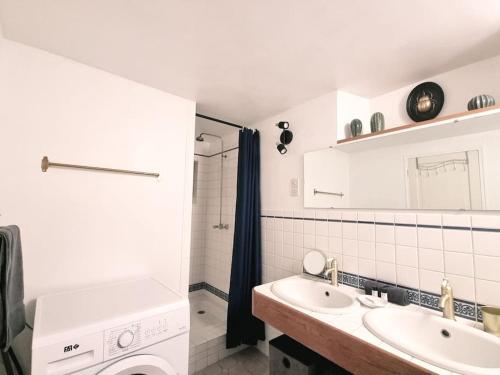 une salle de bain avec un lavabo et une machine à laver dans l'établissement Paris Montmartre 6 Personnes, à Paris