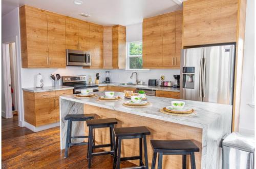 a kitchen with wooden cabinets and a large island with bar stools at Cozy and Gorgeous 2BR1BA Near Amazing Downtown in San Antonio