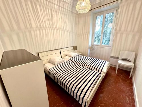 une chambre avec un lit noir et blanc et une fenêtre dans l'établissement Résidence Rauba Capeu, à Nice